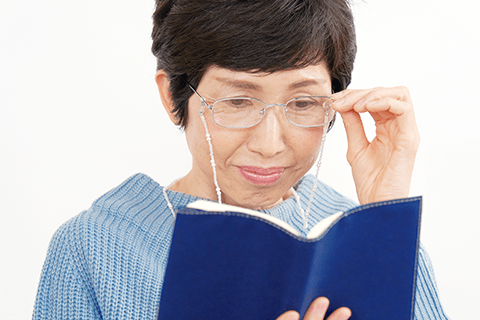 老眼鏡をかけて読書をする女性