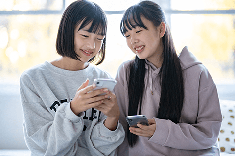 スマートフォンを使用する子ども