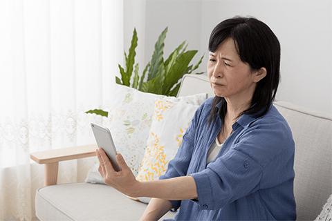 スマートフォンを目を細めて確認している様子