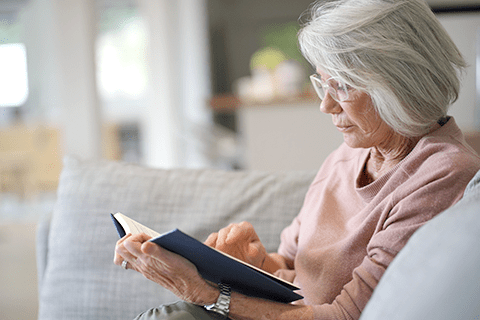 老眼鏡を使って読書する女性