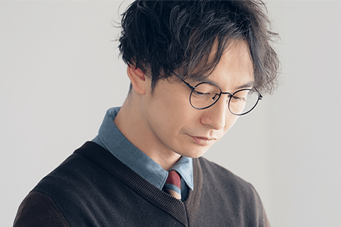 細いフレームのメガネをかけた男性