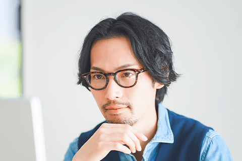 カラーフレームのメガネをかけた男性