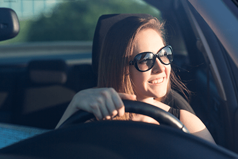 可視光調光レンズをかけて運転する女性