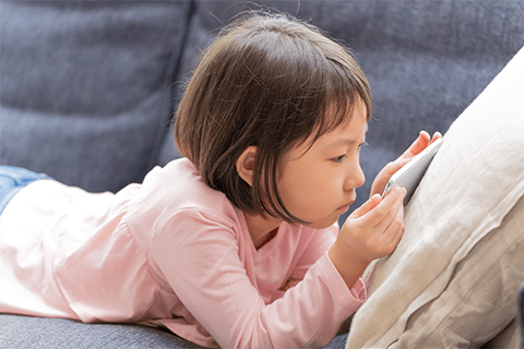 画面を近づけてスマートフォンを操作する女の子