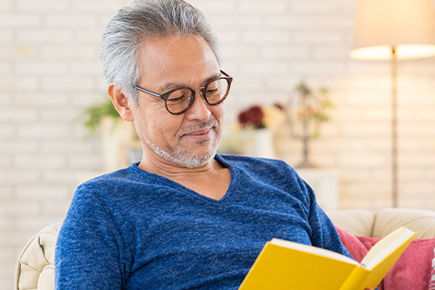メガネをかけて本を読む男性